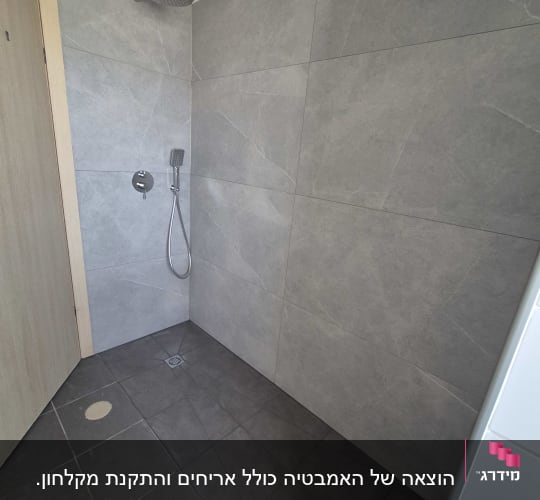 חדר אמבטיה עם אריחים אפורים ומקלחת
